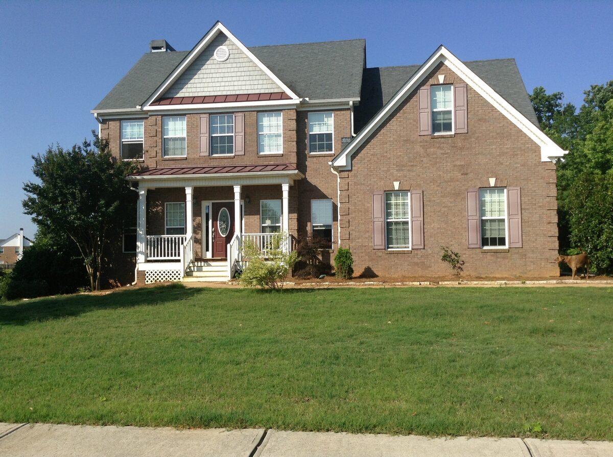 Large two-story home with a partial brick front, shingle siding, and a welcoming front porch, representing residential properties inspected by Northmark Property Inspections in Coleman, WI.