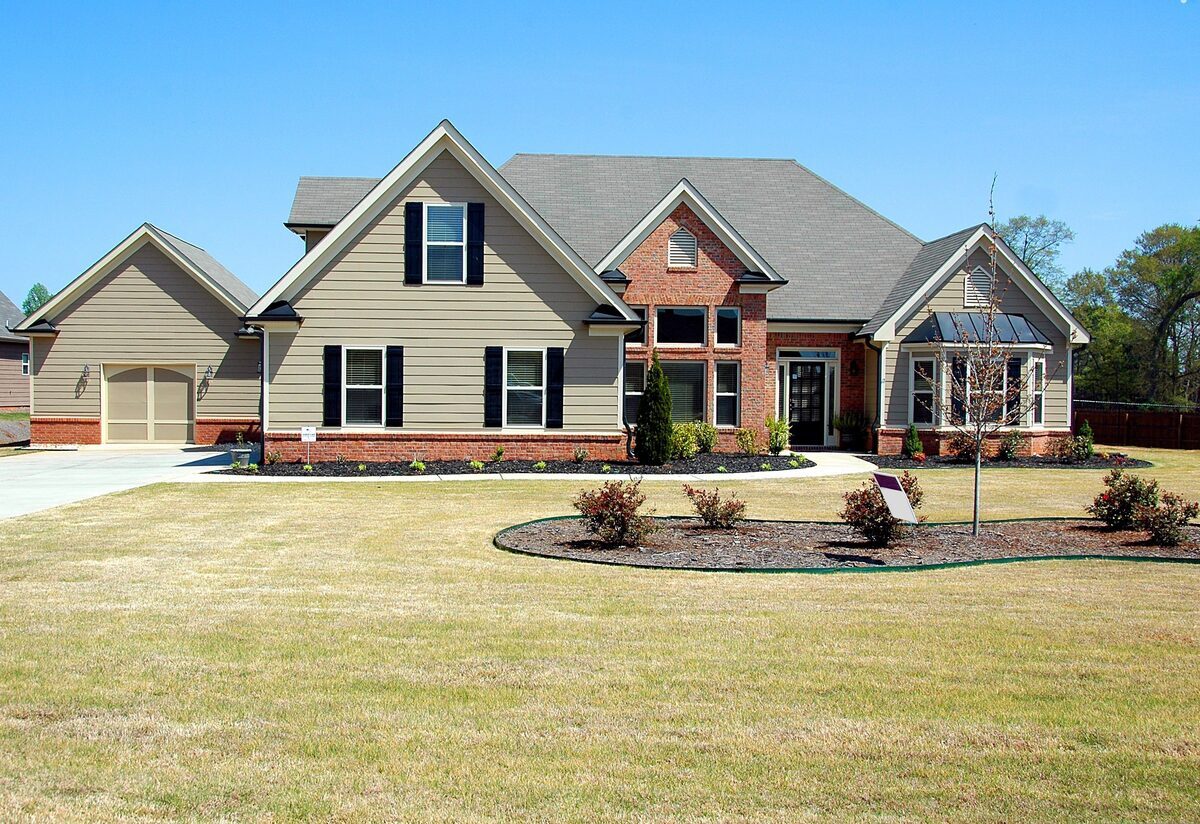 Modern multi-gabled suburban home with siding, brick accents, and a wide front lawn, representing residential properties inspected by Northmark Property Inspections in Green Bay, WI.