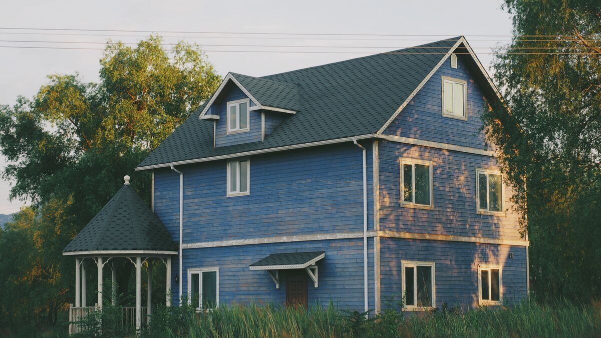 Spacious blue two-story home featuring horizontal wood siding and an attached gazebo, representing residential properties inspected by Northmark Property Inspections in Lena, WI.