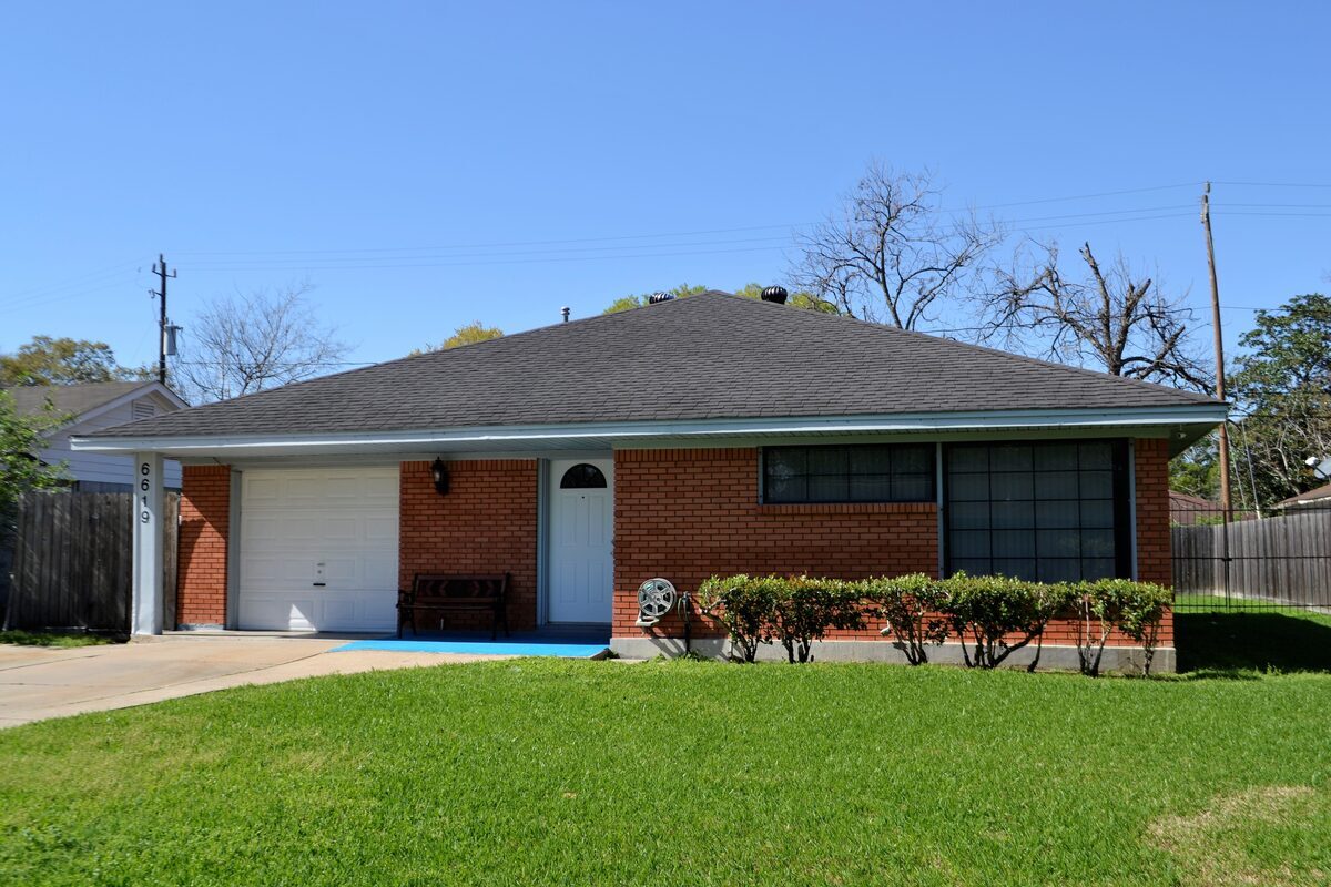 Classic single-story red brick ranch home with an attached garage, representing residential properties inspected by Northmark Property Inspections in Menominee, MI.
