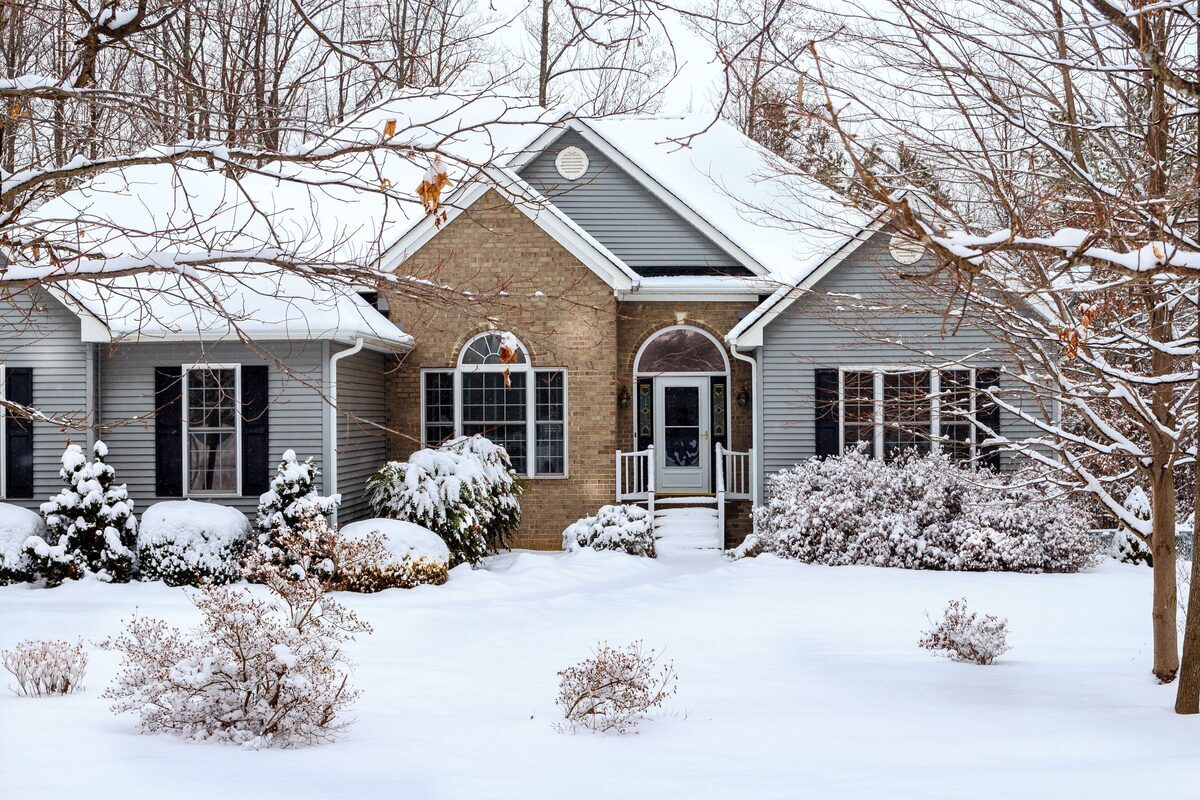 Snow-covered ranch-style home with brick frontage and vinyl siding, representing residential properties inspected by Northmark Property Inspections in Wausaukee, WI.